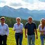 Eine lachende Gruppe von Geschäftsleuten bei einem Outdoor-Teamevent in den Bergen